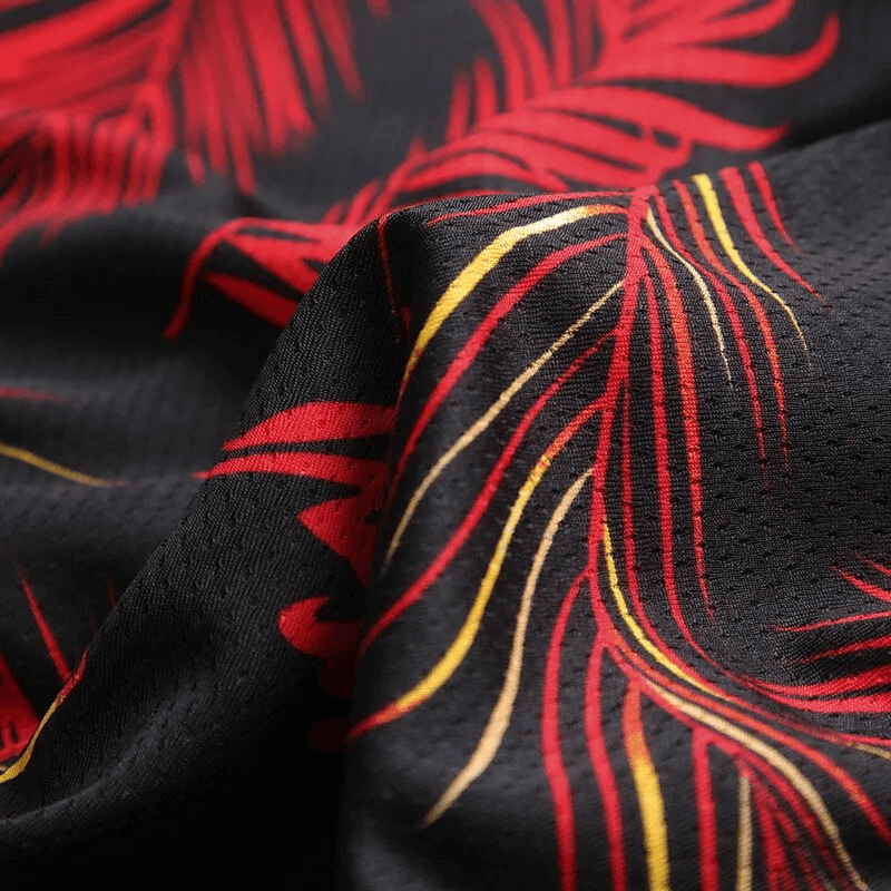 Close-up of red and yellow print design on black men's basketball board shorts fabric.