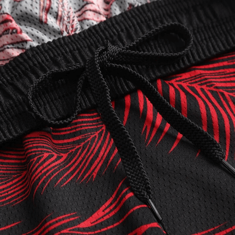 Men's printed basketball shorts with elastic waist and drawstring, featuring red and black design for sports enthusiasts.