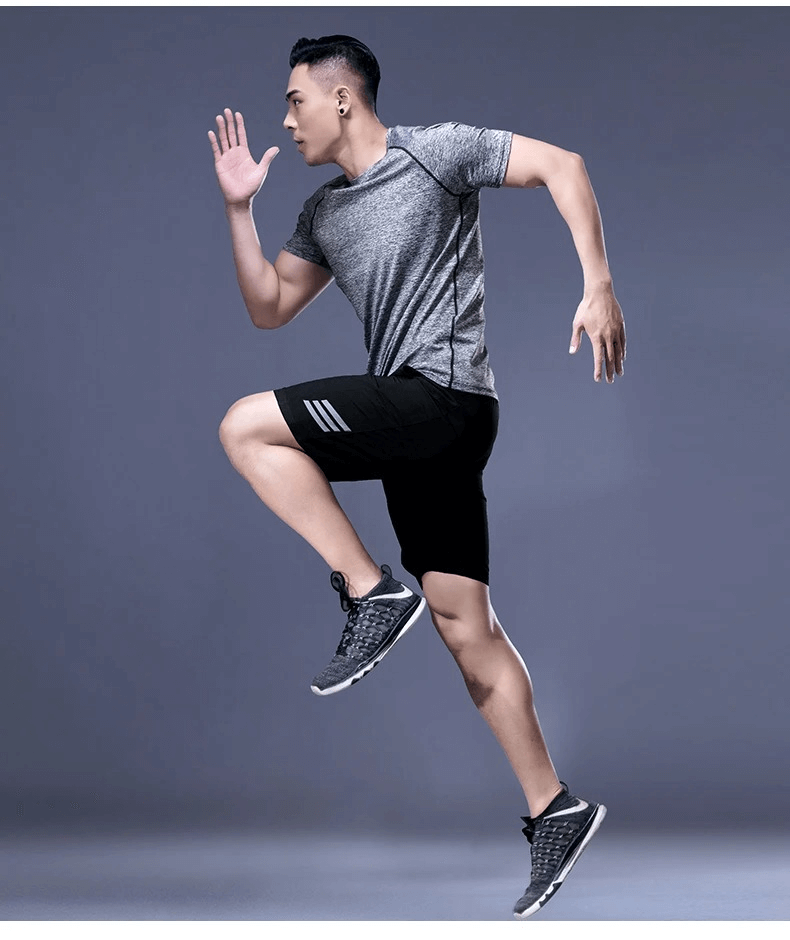 Man in motion wearing Men's Breathable Sportswear SF2027, athletic shirt and shorts set for peak performance and flexibility in workouts.