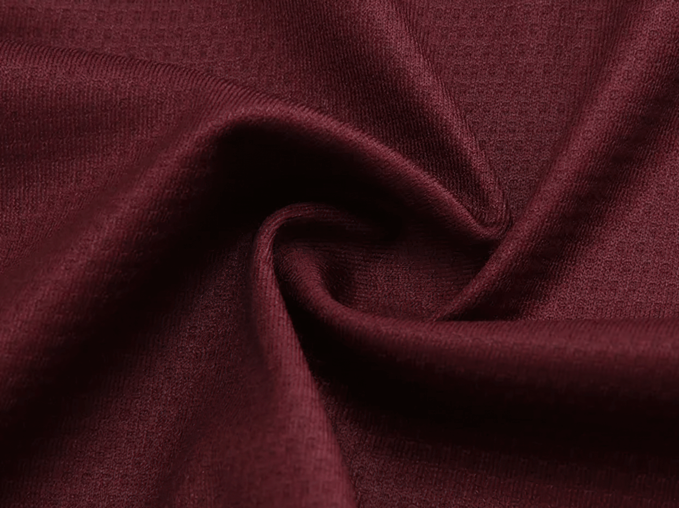 Close-up of burgundy polyester fabric, showcasing texture and quality ideal for men's cycling apparel.