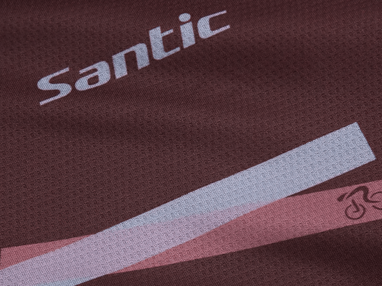 Close-up of maroon Santic men's cycling jersey with geometric design, highlighting breathable fabric texture ideal for MTB and road biking.