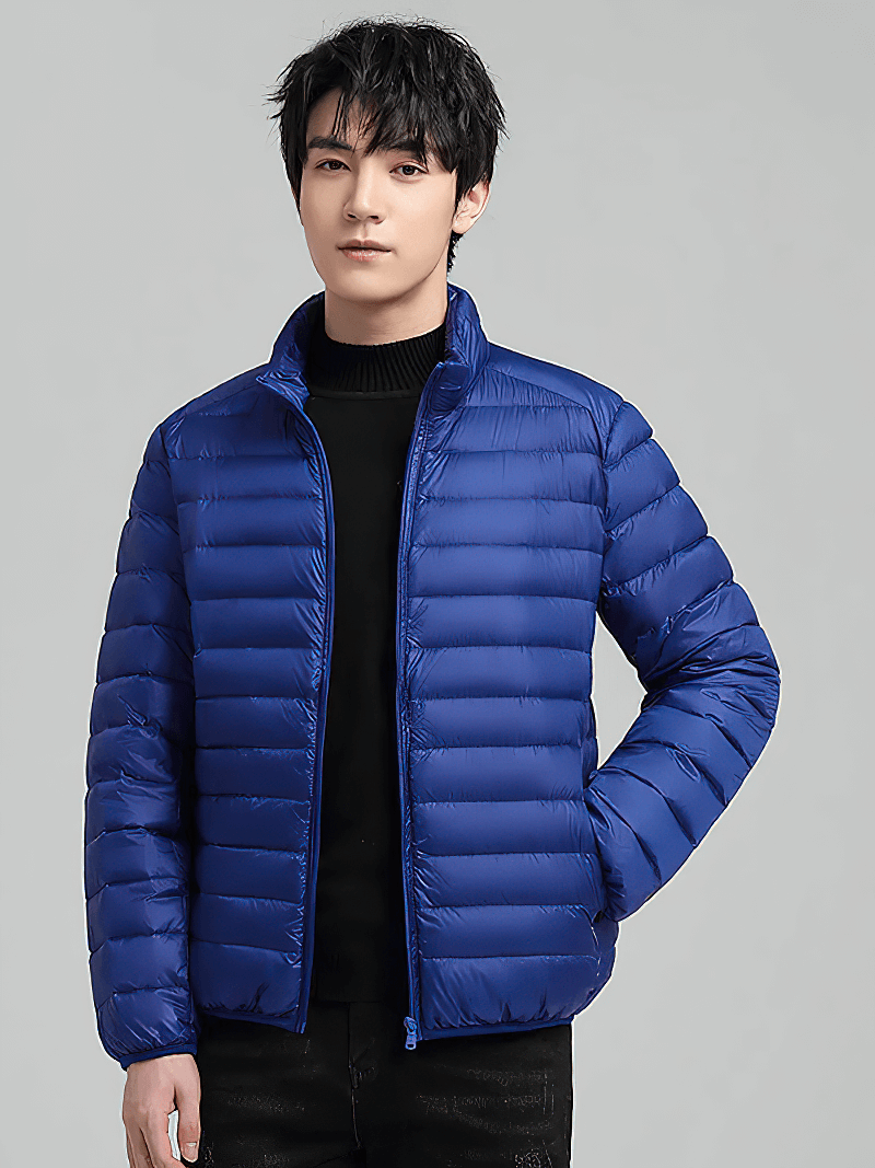 Model wearing men's blue insulated down jacket with stand collar, ideal for outdoor activities, featuring lightweight nylon and duck-down filling.