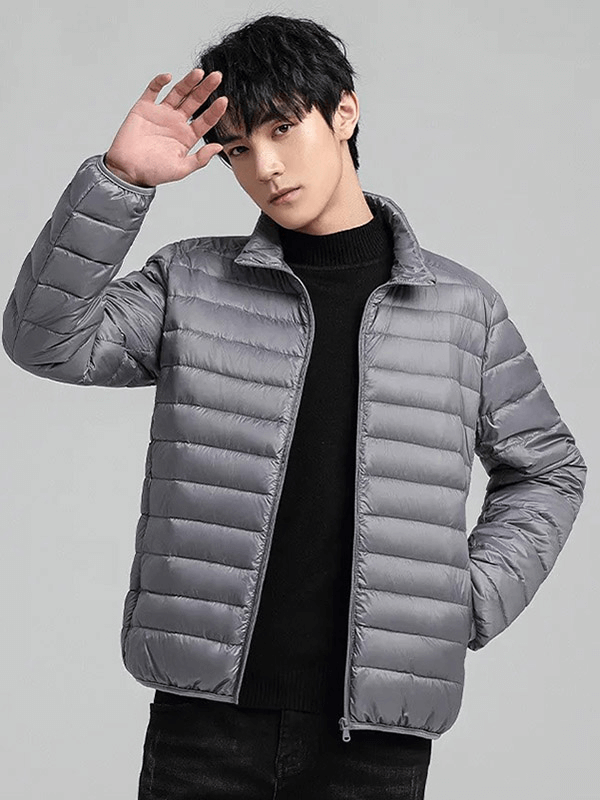 Man wearing gray insulated down jacket with stand collar, showcasing outdoor winter wear. Waterproof, windproof, and stylish.