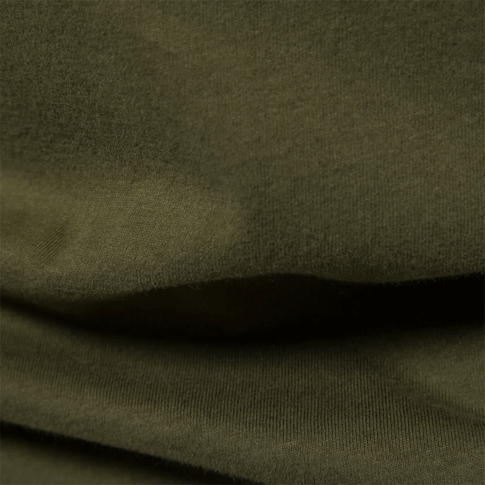 Close-up of olive green cotton fabric texture for men's patchwork top