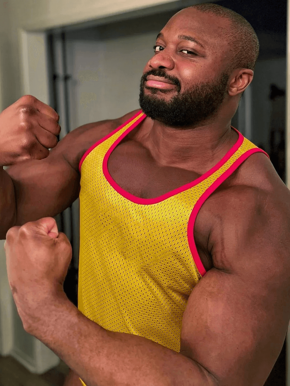 Athlete wearing Men's Mesh Loose Gym Tank Top for Active Wear - SF4170 showing off arms in a yellow sleeveless gym shirt.