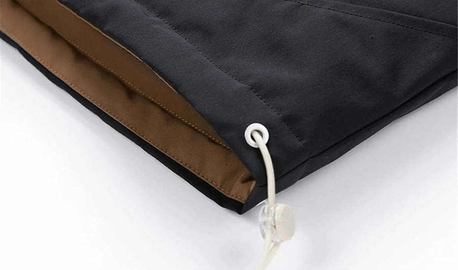 Close-up of men's puffer jacket hem with adjustable drawstring detailing, featuring a water-resistant black exterior and brown inner lining.
