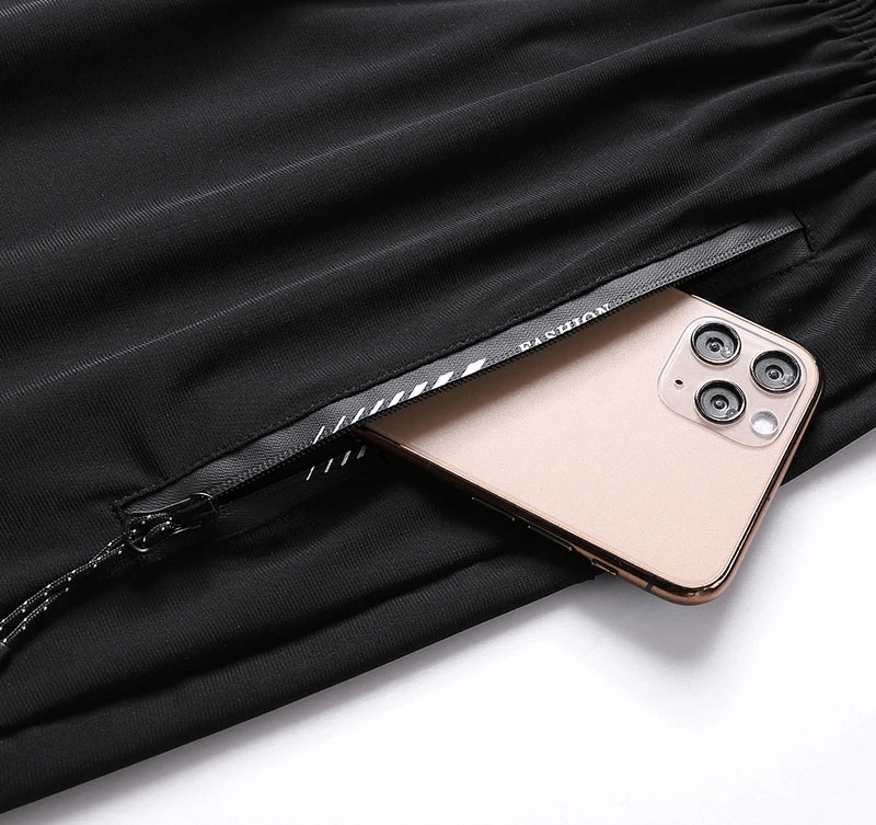 Close-up of black athletic shorts with a phone in a zip pocket, highlighting secure storage feature.