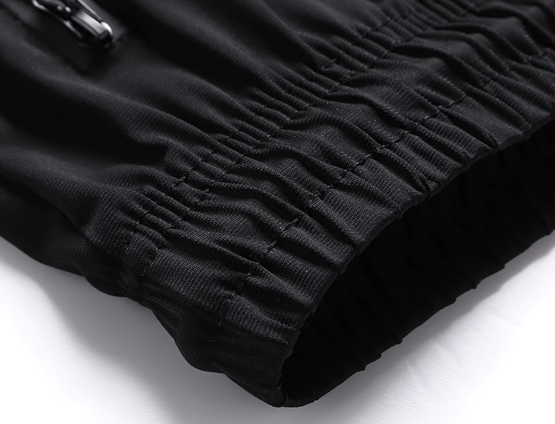 Close-up of black men's quick dry athletic shorts with elastic waist and zip pockets, made of nylon and spandex. Ideal for workouts.