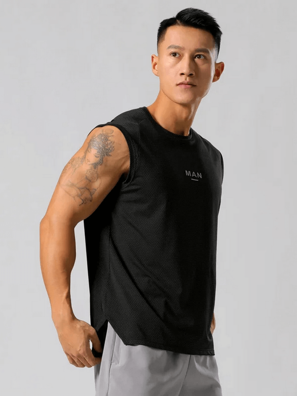 Man wearing black quick-dry elastic tank top for training with stylish stripe patchwork, perfect for jogging and marathons.