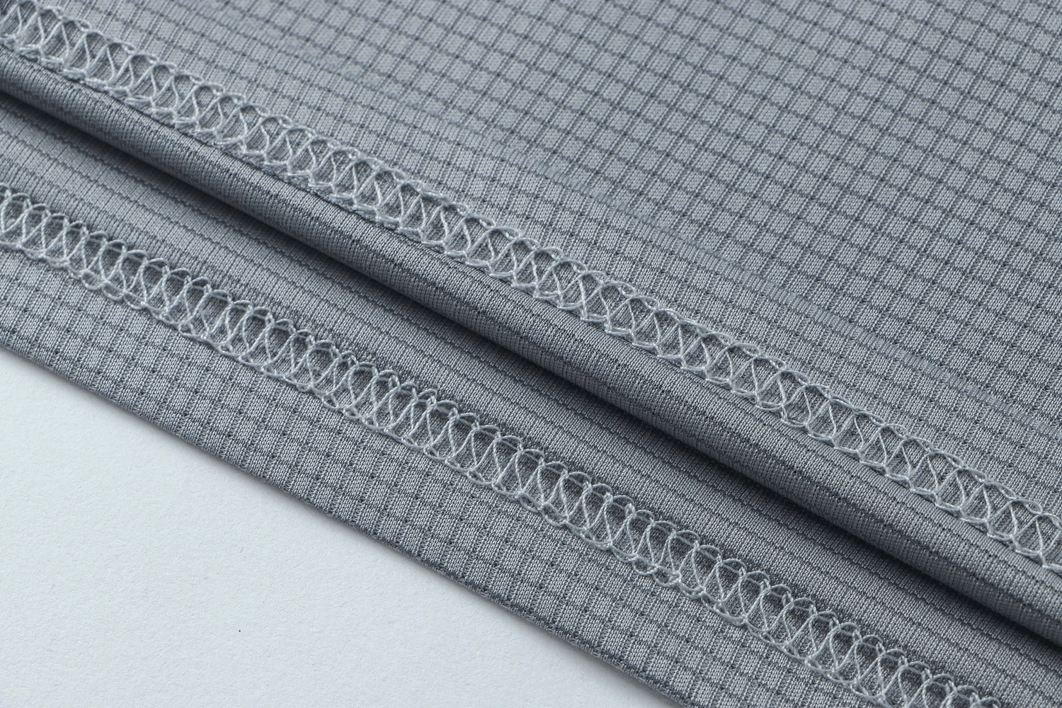 Close-up of gray quick-dry polyester fabric with stitched seams - perfect for men's athletic t-shirts.