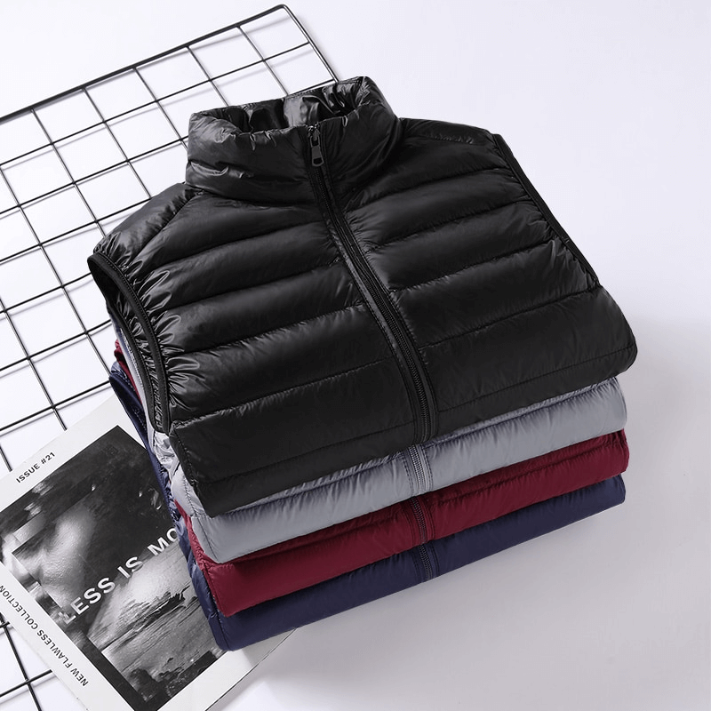Stack of men's quilted lightweight warm down vests with zipper in black, gray, red, and blue, neatly folded on a grid surface.