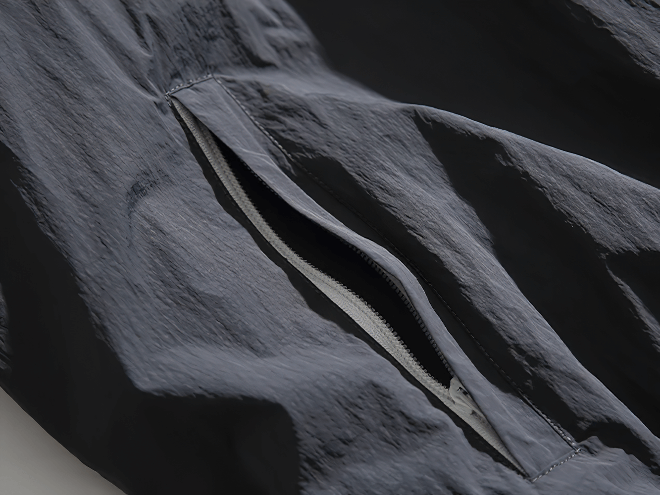 Close-up of men's nylon jacket zipper with reflective strip, showcasing durable patchwork design. Ideal for streetwear style.