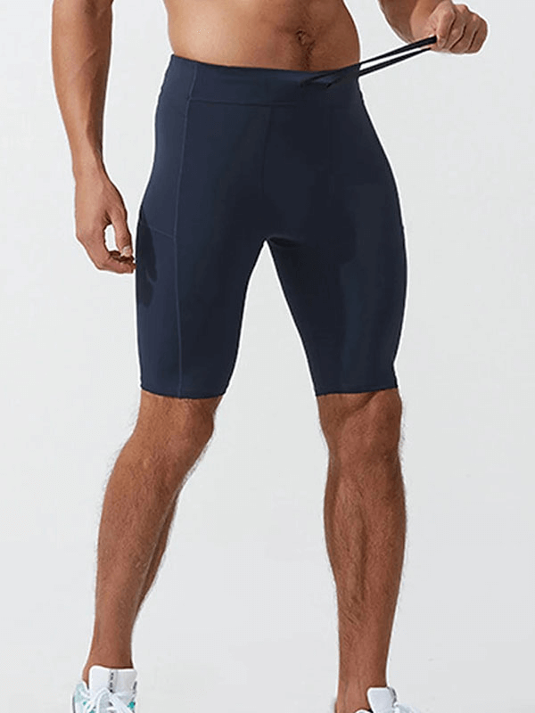 Men's running compression shorts with pockets in navy blue, made from lightweight nylon and spandex, ideal for workouts and sports.