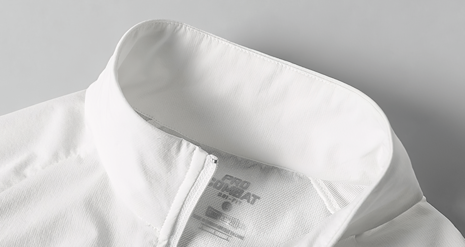 Close-up of men's white long-sleeve running top with half zip, stand collar, and breathable fabric for outdoor sports activities.