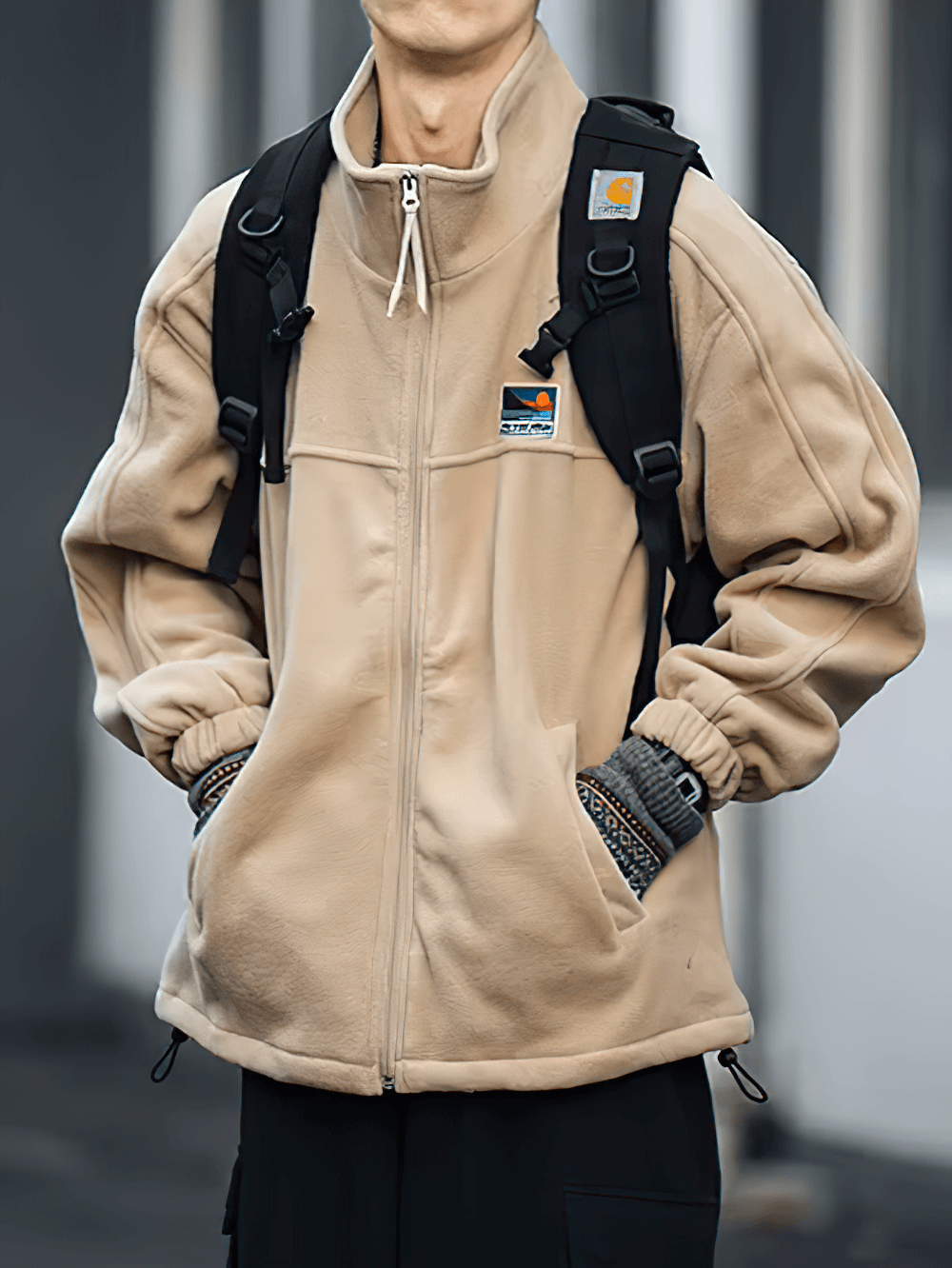 Men's stand collar fleece jacket with zipper, urban streetwear style, beige color, ideal for layering. Model wears backpack and gloves.