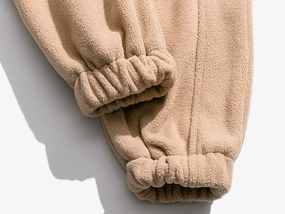 Close-up of beige fleece jacket cuffs highlighting soft texture and casual streetwear style for men.