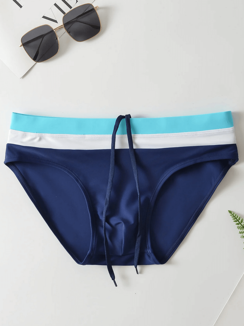 Navy men's swim briefs with drawstring waistband and blue trim, perfect for beachwear and swimming.