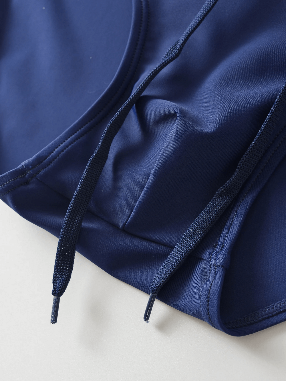 Close-up of blue men's swim briefs with drawstring waistband, sleek design, and durable material for a stylish beach look.