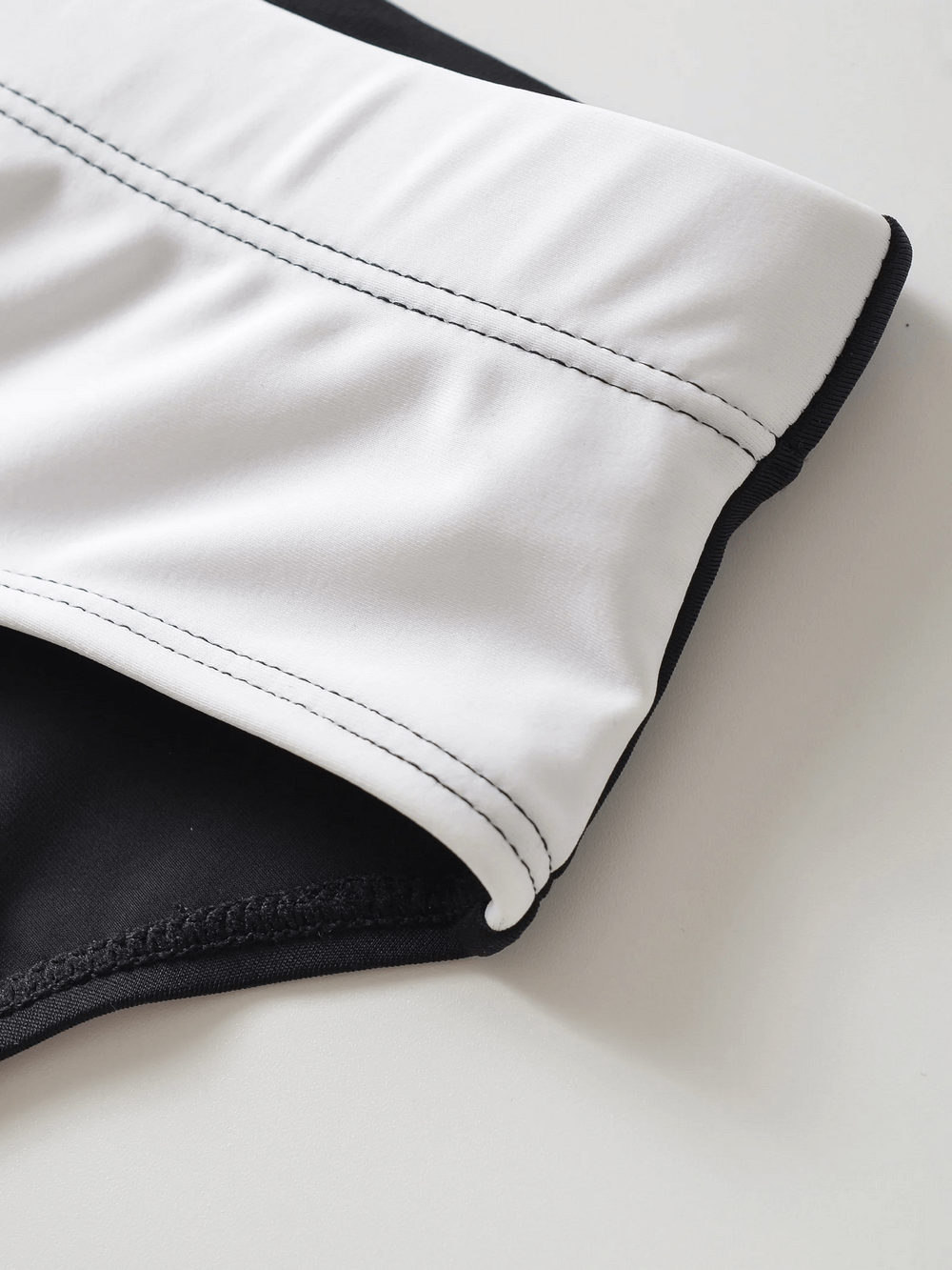 Close-up of men's swim briefs SF2191 with drawstring waistband, showcasing stylish mid-rise design and durable fabric in black and white.