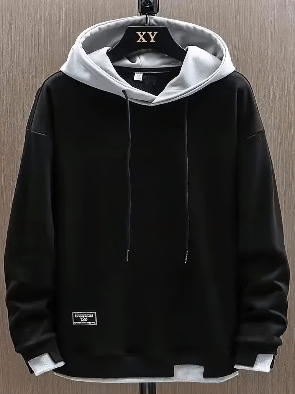 Men's Two-Tone Pullover Hoodie with Layered Hem - SF4675 hanging on a display, featuring a black exterior and contrast gray hood.