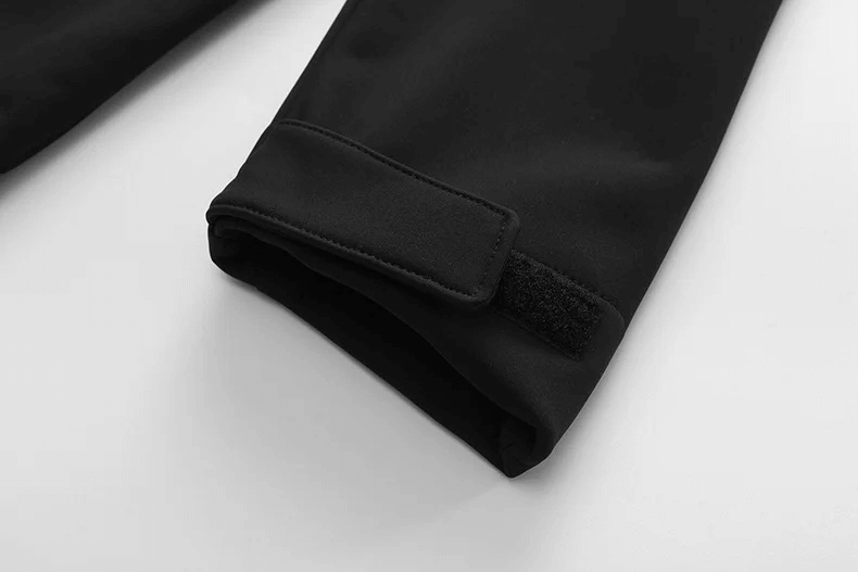 Close-up of Men's Waterproof Softshell Jacket black sleeve featuring adjustable Velcro strap for comfort and fit.