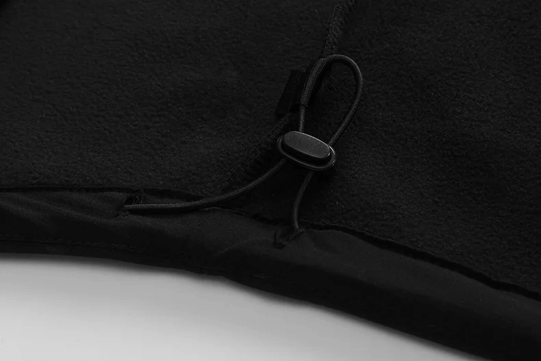 Close-up of black softshell jacket with adjustable drawstring for a secure fit, showcasing durable material and attention to detail.