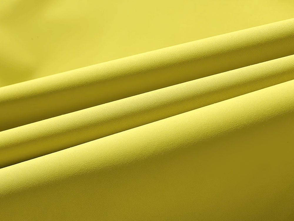 Close-up of bright yellow waterproof fabric for men's windbreaker, showcasing its smooth texture and windproof properties.