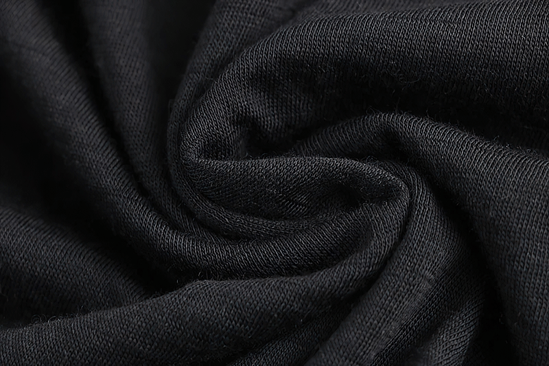 Close-up of black merino wool fabric used in thermal long pants for men, showing texture and fine stitching.