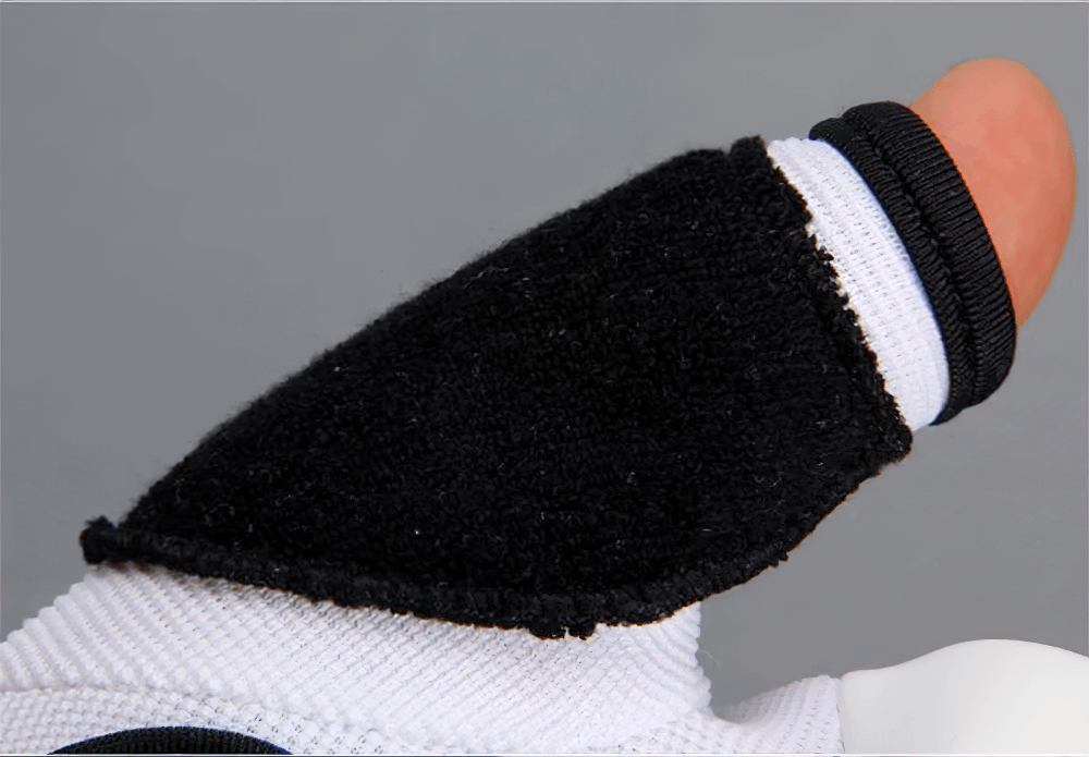 Close-up of black and white MMA sparring glove thumb showcasing durability and comfort.