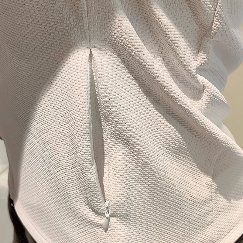 Close-up of modern sporty zip-up jacket with textured fabric showing pocket detail and stylish design, suitable for running.