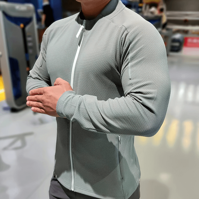Modern grey zip-up textured sports jacket with O-neck and pockets, designed for men, featuring breathability and quick-dry technology.