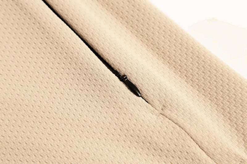 Close-up of textured zip-up sports jacket in breathable cotton, featuring a seamless pocket design for men. Stylish and functional.