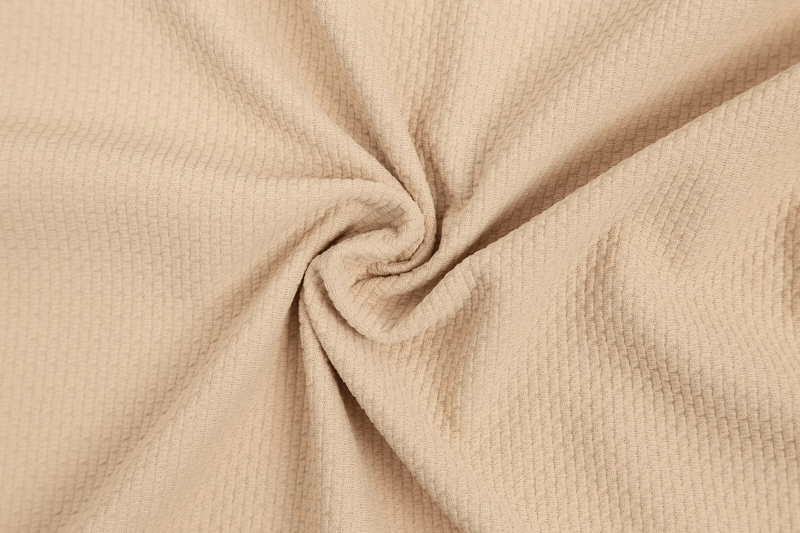 Close-up of beige textured fabric with a swirl pattern, showcasing breathable cotton material used in the Modern Zip-Up Sports Jacket - SF1987.