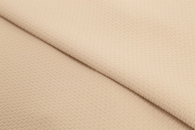 Close-up of a modern beige textured fabric used in men's sports jackets made of breathable cotton and spandex.