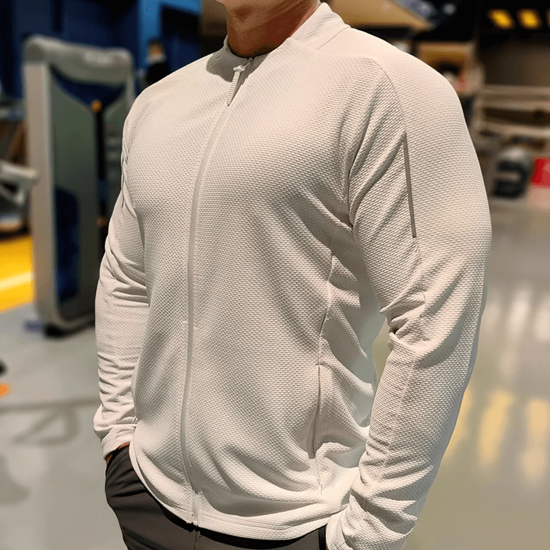 Man wearing a modern zip-up textured sports jacket with pockets, ideal for running, featuring quick-dry and windproof materials.