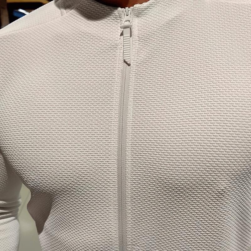 Modern white zip-up textured sports jacket with breathable fabric and pockets, designed for running and comfort.
