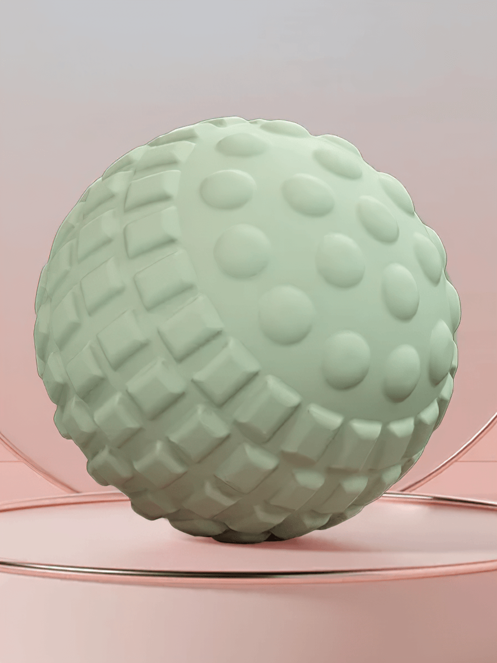 Green textured massage ball for targeted muscle relief on a soft pink background.