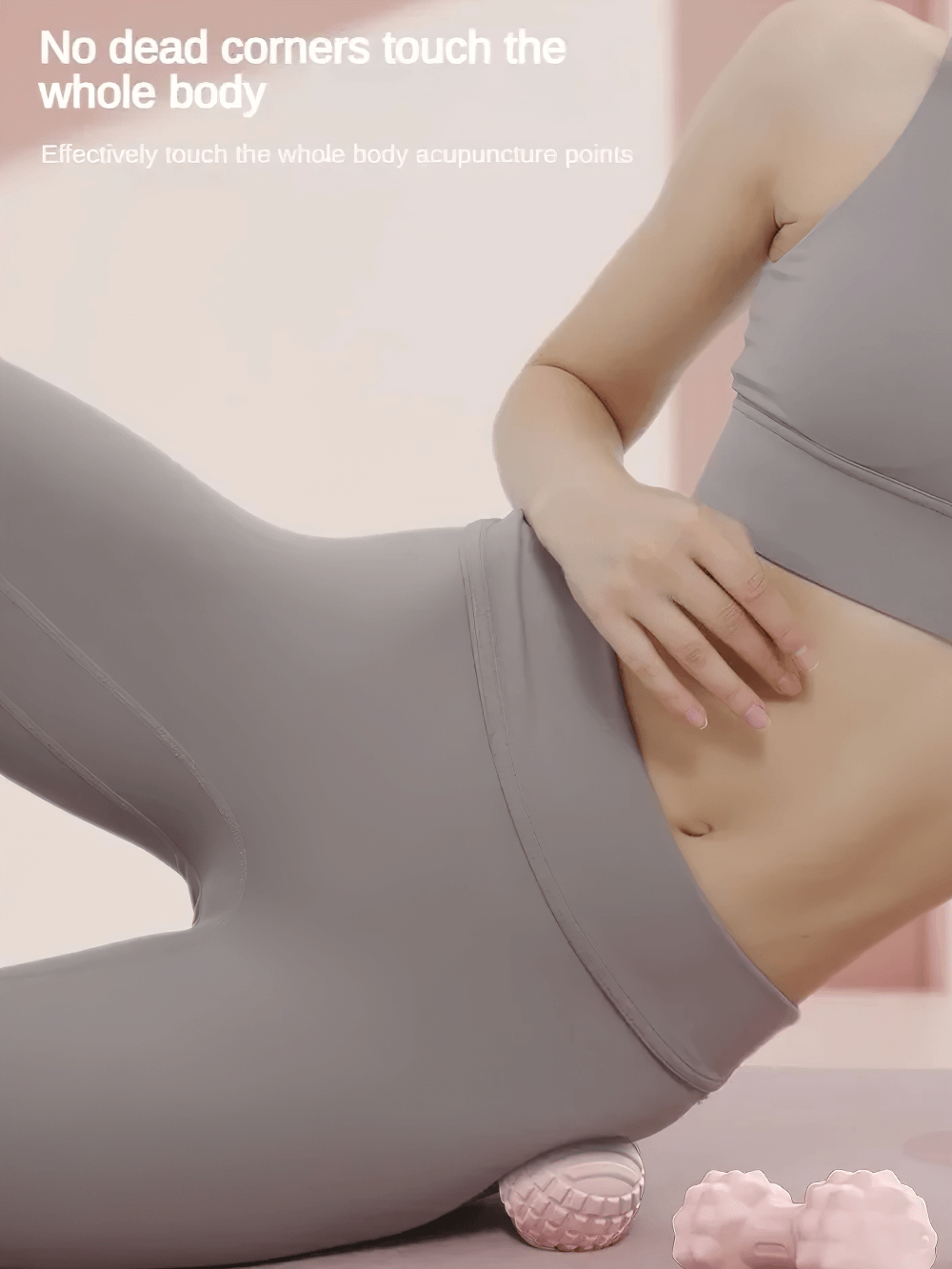 Woman using a massage ball for muscle relief on her lower back, dressed in gray activewear, highlighting full body acupuncture benefits.