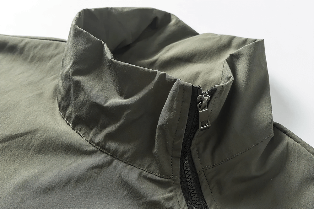 Close-up of green utility jacket collar with zipper, ideal for outdoor adventures and versatile layering.