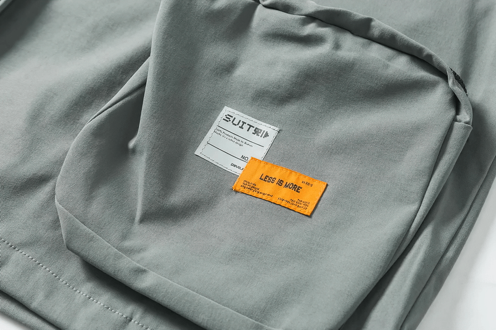 Close-up of multi-pocket utility jacket SF2280 showcasing sleek design and orange label, perfect for outdoor adventures.