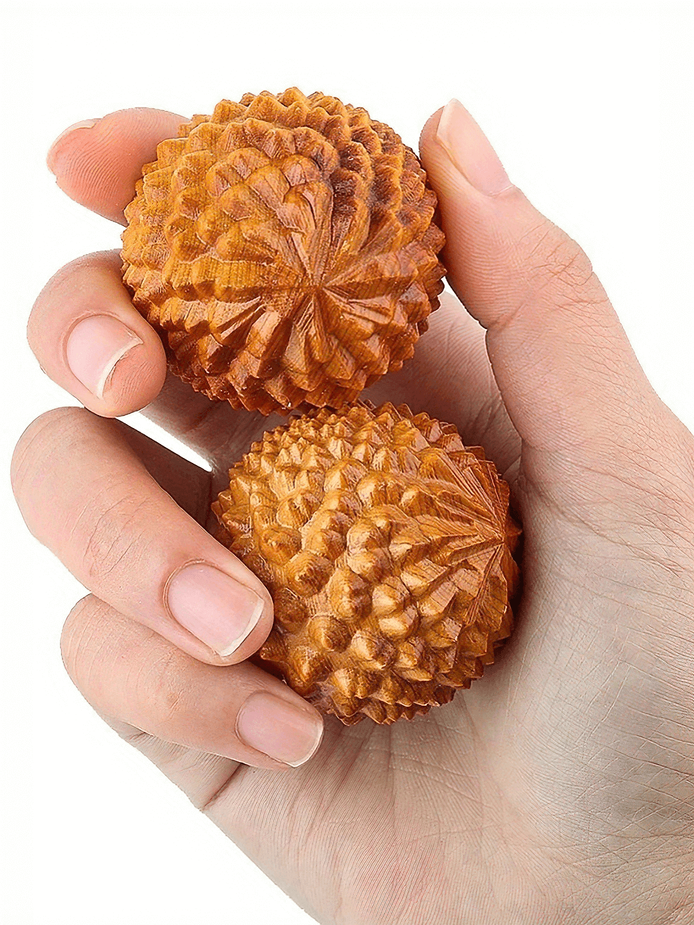 Hand holding natural wooden massage balls for stress relief and relaxation, enhancing circulation and reducing muscle tension.