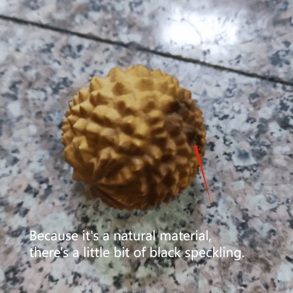 Natural wooden hand massage ball on countertop, showcasing natural variations and texture for stress relief and relaxation.