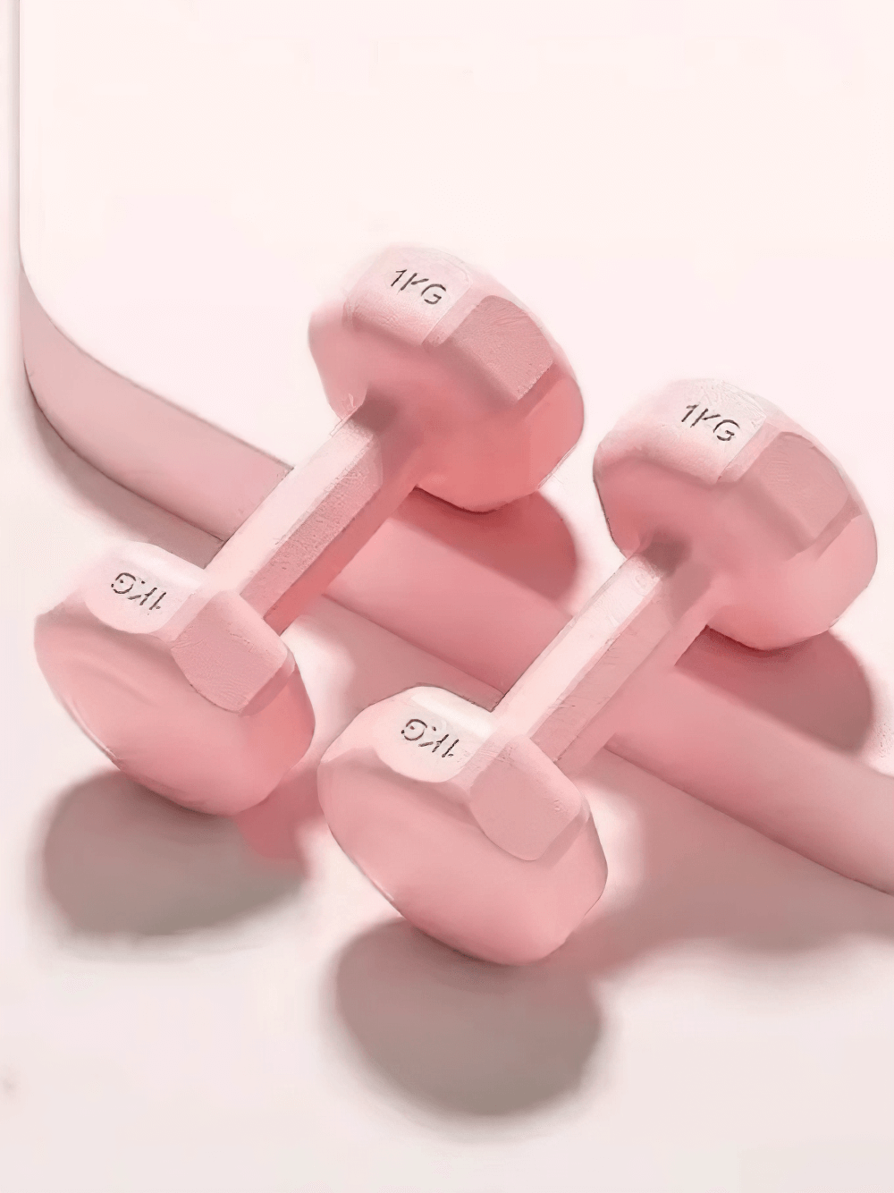 Pink neoprene-coated hexagonal dumbbells for home and gym use, 1kg each, slip-resistant design for strength training.