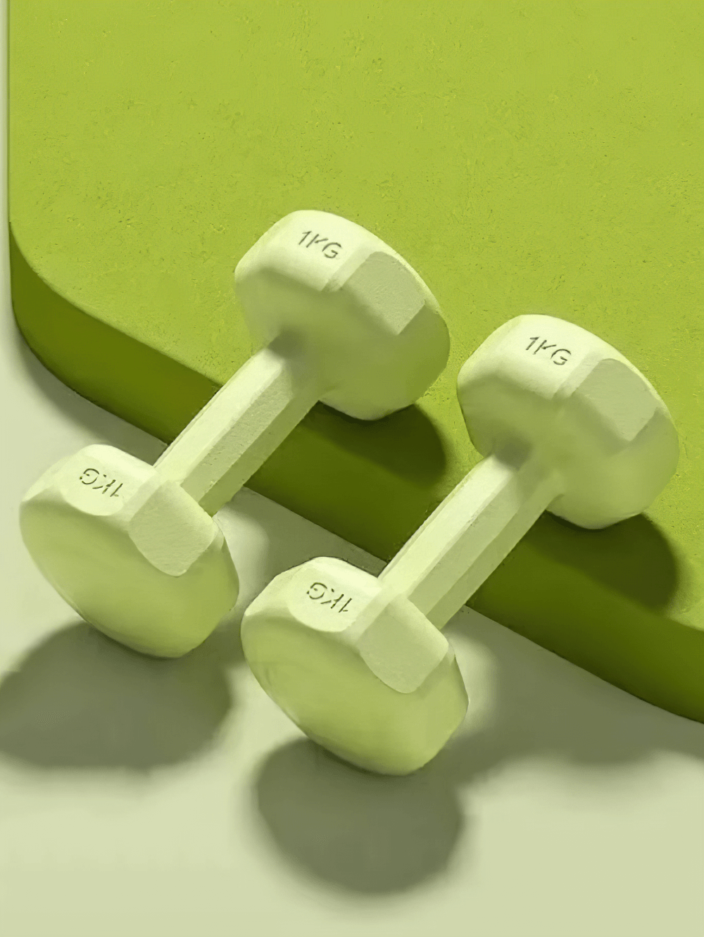 Vibrant neoprene-coated hexagonal dumbbells, perfect for home and gym workouts, shown on a stylish green surface.