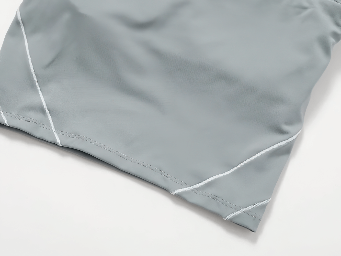 Close-up of gray nylon yoga shorts with white stitching detail, perfect for gym and running. Anti-wrinkle and breathable fabric.