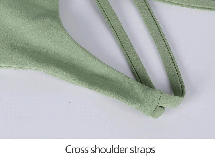 Green nylon sports top with cross shoulder straps showcasing breathable and stretchy fabric for workouts.