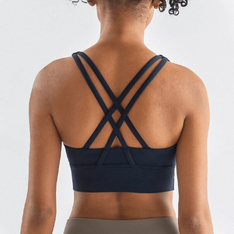 Back view of nylon sports top with cross shoulder straps, designed for women's fitness activities like yoga and running.