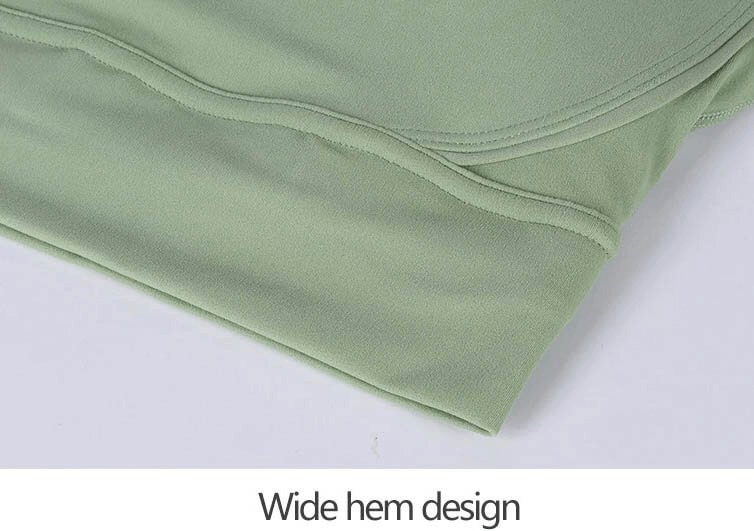 Close-up of a green nylon sports top with cross shoulder straps featuring a wide hem design ideal for yoga, gym, and dance sessions.