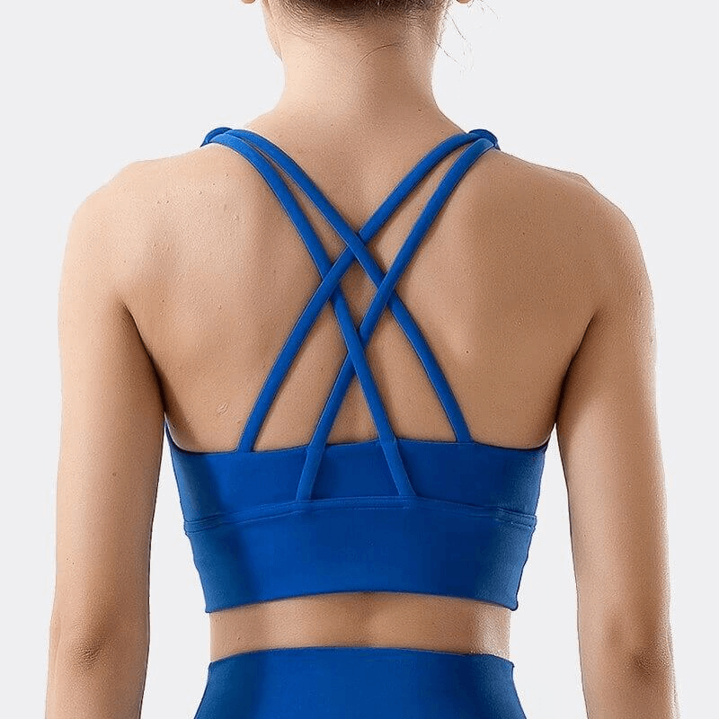Back view of nylon sports top with cross shoulder straps in blue, women's skinny stretch fitness bra, ideal for yoga and gym workouts.