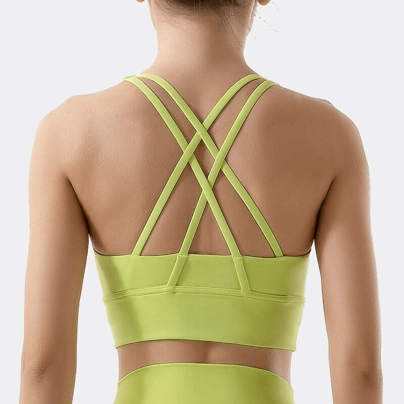 Back view of nylon sports top with cross shoulder straps for women - perfect for yoga and fitness. Model wearing green, product SF0036.